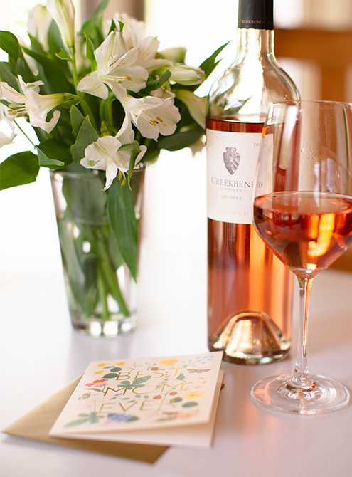 Add a thoughtful card and flowers to Mom's favorite bottle of wine.